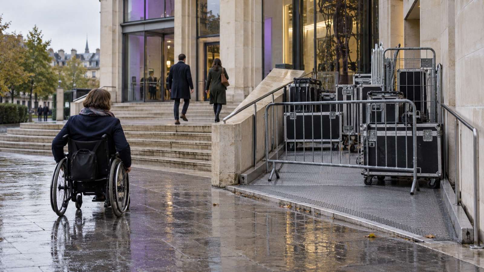 Une personne en fauteuil roulant face à une rampe d’accès temporairement obstruée devant un bâtiment public